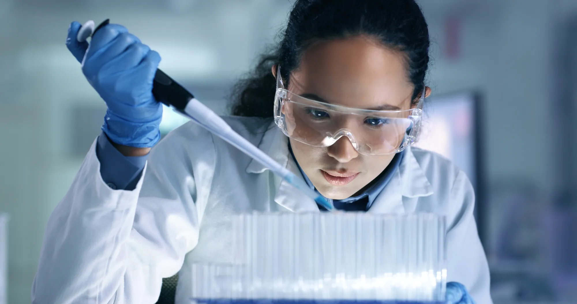 Scientist pipetting environmental samples into test tubes
