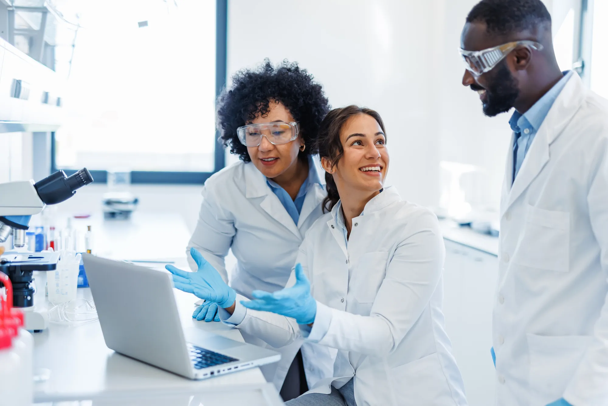 Laboratory team discussing data on a laptop